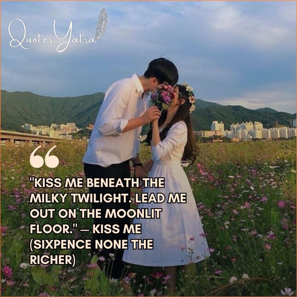 Romantic couple sharing a soft kiss in a flower field at sunset with song lyrics about moonlit love overlaid on the image.